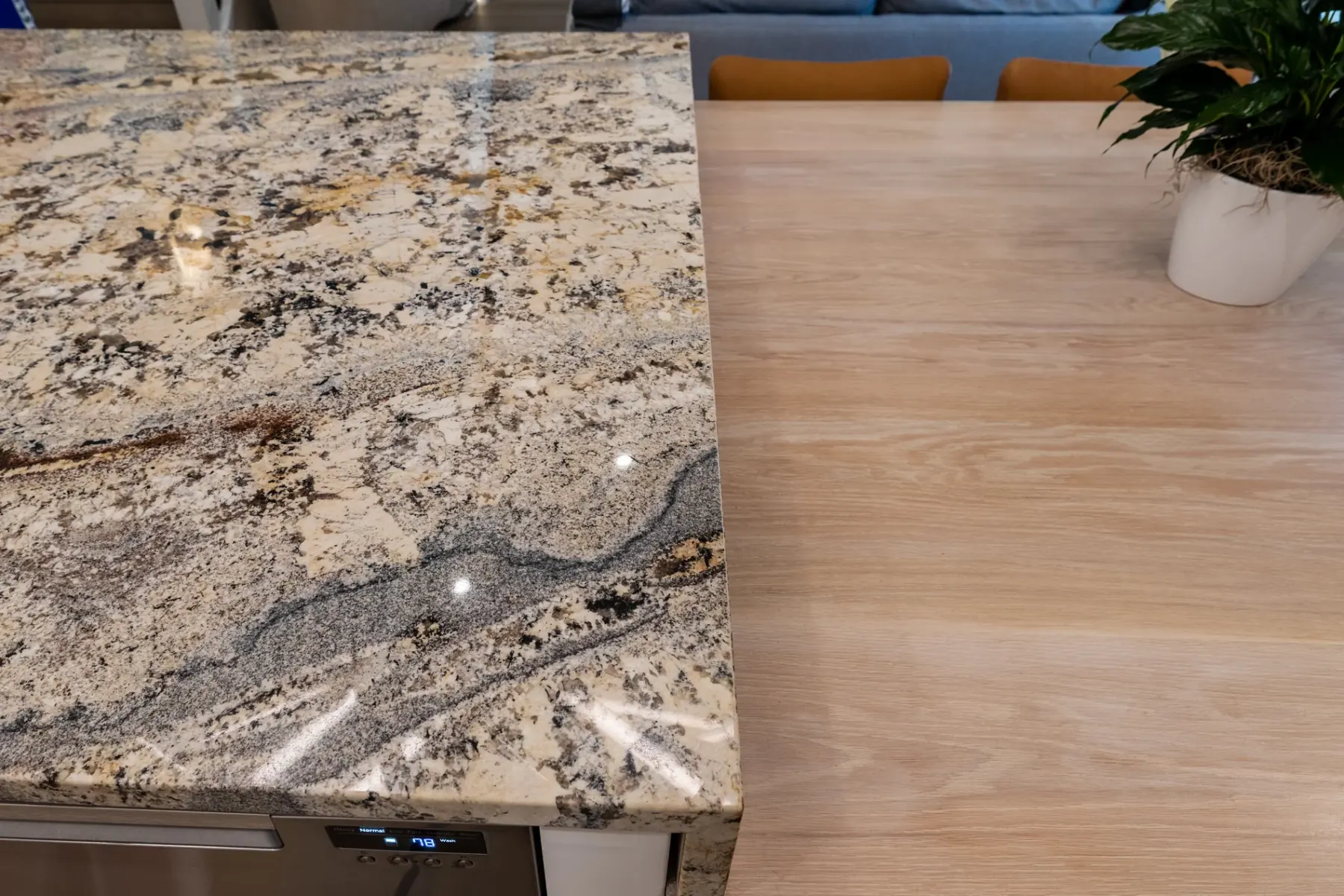 Granite island corner meeting a light wood tabletop, kitchen remodeled by ATX Renovations in Bee Cave